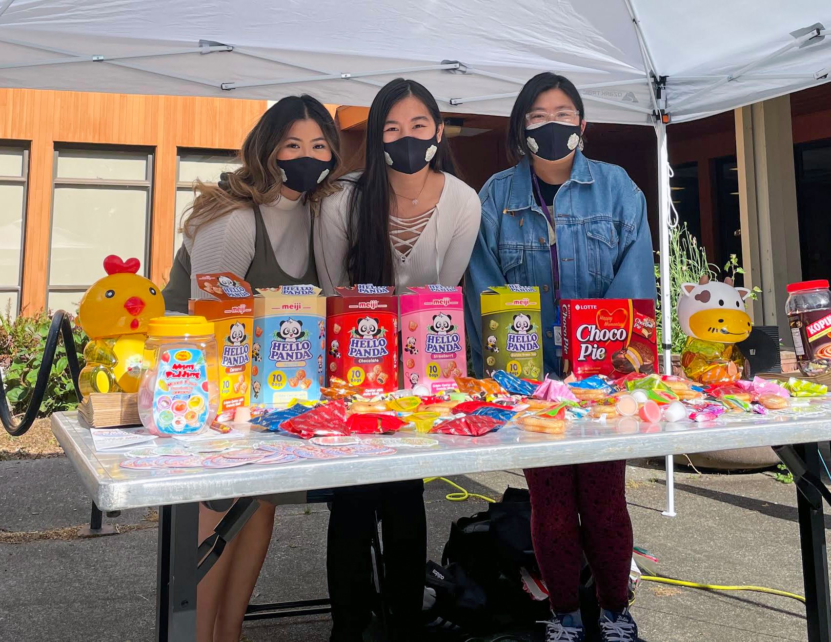 Ha and 2 fellow organizers stand behind AAPI Heritage Month Merch booth