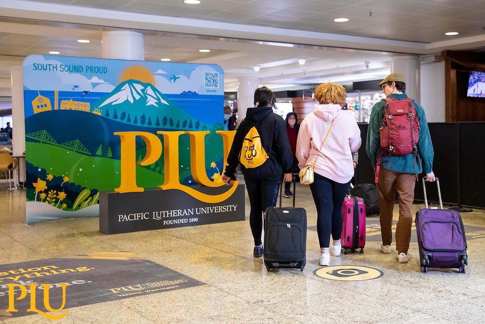 3 students walking towards colorful Seatac Airport mural